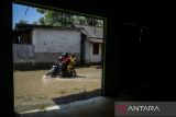 Pengendara sepeda motor melintasi banjir di Desa Gaga, Pakuhaji, Kabupaten Tangerang, Banten, Minggu (6/7/2025). Banjir dengan ketinggian 15 - 30 cm tersebut akibat meluapnya debit Sungai Cisadane yang dipicu air kiriman dari wilayah Bogor dan tingginya curah hujan pada Sabtu (5/7). ANTARA FOTO/Putra M. Akbar/gp