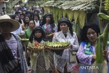 Warga membawa bubur suro dan penganan lain saat kirab pada Festival Bubur Suro di Desa Wisata Bandung, Banjar, Kabupaten Pandeglang, Banten, Minggu (6/7/2025). Festival tahunan yang menghadirkan beragam kegiatan di antaranya pentas seni, lomba pakaian adat, dan kompetisi memasak bubur suro yang dilanjutkan dengan kirab tersebut digelar dalam rangka memperingati Hari Asyura (10 Muharram) 1447 Hijriah sekaligus upaya mempererat kebersamaan antar warga. ANTARA FOTO/Angga Budhiyanto/gp