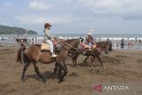 Pengunjung menunggangi kuda di pesisir pantai barat Kabupaten Pangandaran, Jawa Barat, Minggu (6/7/2025). Dinas Pariwisata dan Kebudayaan Kabupaten Pangandaran mencatat jumlah kunjungan wisatawan selama libur sekolah dari 25 Juni 2025 - 5 Juli 2025 di enam objek wisata Pangandaran sebanyak 148.970 pengunjung. ANTARA FOTO/Adeng Bustomi/agr