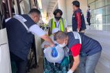 Petugas Panitia Penyelenggara Ibadah Haji (PPIH) Debarkasi Banjarmasin Provinsi Kalimantan Selatan (Kalsel) membantu salah satu jamaah haji dari Kelompok Terbang (Kloter) 12 yang berusia lanjut hendak turun menggunakan kursi roda di Asrama Haji Banjarmasin, Kota Banjarbaru, Minggu (5/7/2025). Ketua PPIH Debarkasi Banjarmasin M. Tambrin menuturkan jumlah total jamaah haji Debarkasi Banjarmasin dari Provinsi Kalimantan Selatan dan Kalimantan Tengah yang tiba di tanah air sebanyak 5.066 jamaah dan petugas haji. ANTARA/HO-PPIH Debarkasi Banjarmasin