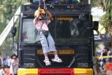 Seorang anak mencoba permainan flying fox saat Hari Bebas Kendaraan Bermotor di Jalan Darmo, Surabaya, Jawa Timur, Minggu (6/7/2025). Sat Samapta Polrestabes Surabaya menggelar permainan flying fox untuk anak, memamerkan personel Pengendalian Massa (Dalmas) berikut peralatannya, Unit K9 dan lain-lain tersebut merupakan kegiatan untuk menyemarakkan HUT ke-79 Bhayangkara yang bertema Polri untuk Masyarakat. ANTARA Jatim/Didik Suhartono/mas.