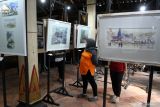 Pengunjung melihat pameran lukisan yang dipajang dalam Festival Wirotani#2 di Omah Joglo Darmo Menggolo, Karangtengah, Ngawi, Jawa Timur, Senin (7/7/2025). Festival seni budaya masyarakat petani tersebut digelar setiap setahun sekali untuk promosi wisata pertanian dengan latar belakang bangunan cagar budaya yakni Omah Joglo yang dibangun pada abad ke-16 di masa kerajaan Mataram sekaligus memberi wadah bagi para seniman untuk mengekspresikan karyanya melalui berbagai kegiatan seni seperti pertunjukan kesenian dan pameran lukisan. ANTARA Jatim/Ari Bowo Sucipto/mas.
