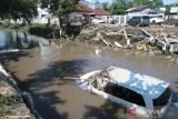 Sebuah mobil terseret banjir di sungai di Mataram, NTB, Senin (7/7/2025). Pemerintah Kota Mataram Provinsi NTB menyatakan banjir yang melanda pada Minggu (6/7/2025) mengakibatkan sebanyak 7.676 rumah terendam, 7.676 kepala keluarga (KK) atau sekitar 30.681 jiwa mengungsi dan satu orang meninggal dunia karena tersengat listrik di Ampenan. ANTARA FOTO/Dhimas Budi Pratama/sgd/rwa.