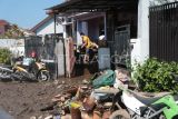 Warga membersihkan rumahnya pascabanjir di Mataram, NTB, Senin (7/7/2025). Pemerintah Kota Mataram Provinsi NTB menyatakan banjir yang melanda pada Minggu (6/7/2025) mengakibatkan sebanyak 7.676 rumah terendam, 7.676 kepala keluarga (KK) atau sekitar 30.681 jiwa mengungsi dan satu orang meninggal dunia karena tersengat listrik di Ampenan. ANTARA FOTO/Dhimas Budi Pratama/sgd/rwa.