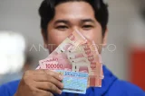 Pekerja menunjukkan uang Bantuan Subsidi Upah (BSU) 2025 tahap kedua yang diterima di Kantor Pos Samarinda, Kalimantan Timur, Senin (7/7/2025). Berdasarkan data dari BPJS Ketenagakerjaan, jumlah penerima BSU tahap kedua tercatat sebanyak 4,5 juta pekerja atau buruh sebesar Rp600 ribu per orangnya. Antara Kaltim/M Risyal Hidayat/foc.