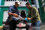 Petugas cek fisik kendaraan memeriksa berkas warga sebelum melakukan proses penggesekan nomor rangka dan mesin kendaraan bermotor dalam kegiatan SAMSAT Goes to Kecamatan (GOKATAN) di Kantor Camat Pontianak Selatan, Kalimantan Barat, Selasa (8/7/2025). Samsat Gokatan merupakan inovasi layanan publik yang diselenggarakan UPT PPD Pontianak Wilayah I Bapenda Provinsi Kalbar untuk memudahkan masyarakat membayar pajak kendaraan melalui sistem jemput bola, disertai fasilitas bebas denda serta pemberian diskon antara 5 persen hingga 50 persen. ANTARA FOTO/Jessica Wuysang