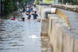 Sejumlah anak bermain saat banjir di Perumahan Pondok Maharta, Pondok Aren, Tangerang Selatan, Banten, Selasa (8/7/2025). Banjir yang menggenangi permukiman warga tersebut disebabkan tingginya curah hujan serta sistem drainase yang buruk. ANTARA FOTO/Rivan Awal Lingga/tom.