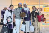 Jamaah haji Kelompok Terbang (Kloter) 13 atau terakhir yang terdiri dari 425 orang asal Debarkasi Banjarmasin tersenyum bahagia sambil foto bersama saat tiba di Bandara Syamsudin Noor Banjarmasin, Banjarbaru, Provinsi Kalimantan Selatan (Kalsel), Selasa (8/7/2025). Panitia Penyelenggara Ibadah Haji (PPIH) Debarkasi Banjarmasin mencatat 5.487 jamaah termasuk petugas haji telah kembali ke tanah air yang berasal dari Provinsi Kalsel dan Kalimantan Tengah (Kalteng), sedangkan 13 jamaah dinyatakan wafat dan dua jamaah masih di Arab Saudi. ANTARA/HO-PPIH Debarkasi Banjarmasin