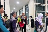 Jamaah haji Kelompok Terbang (Kloter) 13 atau terakhir yang terdiri dari 425 orang asal Debarkasi Banjarmasin melintasi lorong saat tiba di Bandara Syamsudin Noor Banjarmasin, Banjarbaru, Provinsi Kalimantan Selatan (Kalsel), Selasa (8/7/2025). Panitia Penyelenggara Ibadah Haji (PPIH) Debarkasi Banjarmasin mencatat 5.487 jamaah termasuk petugas haji telah kembali ke tanah air yang berasal dari Provinsi Kalsel dan Kalimantan Tengah (Kalteng), sedangkan 13 jamaah dinyatakan wafat dan dua jamaah masih di Arab Saudi. ANTARA/HO-PPIH Debarkasi Banjarmasin