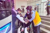 Petugas bandara membantu salah satu jamaah haji berusia lanjut dari Kelompok Terbang (Kloter) 13 atau terakhir Debarkasi Banjarmasin menggunakan kursi roda saat hendak menumpang bus angkutan haji di Bandara Syamsudin Noor Banjarmasin, Banjarbaru, Provinsi Kalimantan Selatan (Kalsel), Selasa (8/7/2025). Panitia Penyelenggara Ibadah Haji (PPIH) Debarkasi Banjarmasin mencatat 5.487 jamaah termasuk petugas haji telah kembali ke tanah air yang berasal dari Provinsi Kalsel dan Kalimantan Tengah (Kalteng), sedangkan 13 jamaah dinyatakan wafat dan dua jamaah masih di Arab Saudi. ANTARA/HO-PPIH Debarkasi Banjarmasin