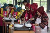 Peserta membuat hidangan saat lomba memasak menggunakan kompor induksi di Graha Bhakti Karya Modernland, Cipondoh, Kota Tangerang, Banten,Â Kamis (10/7/2025). Kompetisi memasak tersebut untuk mensosialisasikan penggunaan kompor induksi yang mengubah energi listrik menjadi energi panas dengan keunggulan lebih aman, hemat energi dan ramah lingkungan. ANTARA FOTO/Putra M. Akbar/gp