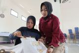 Petugas permasyarakatan mendampingi Warga Binaan Pemasyarakatan (WBP) yang sedang belajar membatik di Lapas Perempuan Kelas IIA Pontianak, Sungai Kakap, Kabupaten Kubu Raya, Kalimantan Barat, Kamis (10/7/2025). Kegiatan tersebut merupakan pelatihan kemandirian dan keterampilan dari Lapas Perempuan Kelas IIA Pontianak untuk membekali warga binaan dengan keterampilan membatik, agar setelah bebas mereka dapat hidup mandiri dan memiliki penghasilan. ANTARA FOTO/Jessica Wuysang