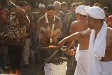 Stafsus Menteri Kebudayaan bidang Sejarah dan Perlindungan Warisan Budaya, Basuki Yuwono (tengah) dan Bupati Tulungagung Gatut Sunu Wibowo (kiri) simbolis menempa baja bercampur bahan meteorit menjadi sebuah pusaka keris dalam Festival Budaya Spiritual 2025 di Pendopo Kongas Arum Kusumaning Bongso, Tulungagung, Jawa Timur, Kamis (10/7/2025). Demo pembuatan keris itu dimaksudkan sebagai upaya pelestarian nilai-nilai budaya adiluhung dan spiritualitas Nusantara, sekaligus menjadi ruang dialog lintas budaya dan pengenalan tradisi lokal ke generasi muda. ANTARA Jatim/Destyan Sujarwoko/mas.