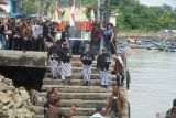 Empat tokoh adat diikuti arak-arakan sesaji menuruni anak tangga sembari membawa anglo yang mengeluarkan asap pembakaran kemenyan di Dermaga Pelabuhan Perikanan Pantai Popoh, Tulungagung, Jawa Timur, Minggu (6/7/2025). Tradisi tahunan labuh laut sembonyo itu digelar sebagai wujud syukur nelayan atas hasil tangkapan ikan yang melimpah, sekaligus ikhtiar masyarakat adat pesisir setempat dalam melestarikan budaya leluhur yang telah diwariskan selama ratusan tahun. ANTARA Jatim/Destyan Sujarwoko/mas.
