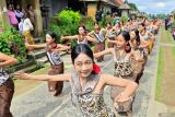 Penari menampilkan tari kolosal di dekat deretan rumah tradisional saat pembukaan Penglipuran Village Festival 2025 di Desa Wisata Penglipuran, Bangli, Bali, Kamis (10/7/2025). Festival tersebut diselenggarakan untuk mempromosikan berbagai potensi seni, budaya dan ekonomi kreatif masyarakat setempat guna meningkatkan kunjungan wisatawan sekaligus mengembangkan industri pariwisata yang inklusif dan berkelanjutan. ANTARA FOTO/Fikri Yusuf/wsj.