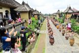 Penari menampilkan tari kolosal di dekat deretan rumah tradisional saat pembukaan Penglipuran Village Festival 2025 di Desa Wisata Penglipuran, Bangli, Bali, Kamis (10/7/2025). Festival tersebut diselenggarakan untuk mempromosikan berbagai potensi seni, budaya dan ekonomi kreatif masyarakat setempat guna meningkatkan kunjungan wisatawan sekaligus mengembangkan industri pariwisata yang inklusif dan berkelanjutan. ANTARA FOTO/Fikri Yusuf/wsj.