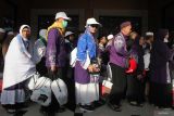 Jamaah haji dari kelompok terbang (kloter) 97 berjalan menuju gedung Muzdalifah setibanya di Asrama Haji Sukolilo Surabaya, Surabaya, Jawa Timur, Jumat (11/7/2025). Pihak Panitia Penyelenggara Ibadah Haji (PPIH) Debarkasi Surabaya menerima kedatangan 322 haji yang merupakan kloter terakhir yang tiba di Surabaya usai menunaikan ibadah haji di Tanah Suci. Antara Jatim/Didik Suhartono/um