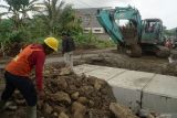 Pekerja menggunakan alat berat memasang box culvert di jalan sirip JLS Besuki, Tulungagung, Jawa Timur, Minggu (7/6/2025). Pemasangan struktur beton bertulang itu bertujuan untuk meningkatkan kapasitas drainase di jalan sirip JLS Tulungagung sehingga bisa meminimalkan risiko/potensi banjir yang kerap melanda wilayah tersebut. Antara Jatim/Destyan Sujarwoko/um