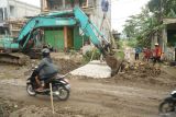 Pekerja menggunakan alat berat memasang box culvert di jalan sirip JLS Besuki, Tulungagung, Jawa Timur, Minggu (7/6/2025). Pemasangan struktur beton bertulang itu bertujuan untuk meningkatkan kapasitas drainase di jalan sirip JLS Tulungagung sehingga bisa meminimalkan risiko/potensi banjir yang kerap melanda wilayah tersebut. Antara Jatim/Destyan Sujarwoko/um