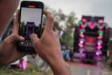 Warga mengabadikan gambar saat menyaksikan gelaran Urek Urek Carnival yang diiringi audio kapasitas besar di Desa Urek-urek Kecamatan Gondanglegi, Kabupaten Malang, Jawa Timur, Sabtu (12/7/2025). Karnaval dengan iringan-iringan audio kapasitas besar tersebut diselenggarakan tiap tahun saat momen selamatan desa atau setelahnya dalam rangka memeriahkan bersih desa yang diperingati pada bulan Suro pada penanggalan Jawa. Antara Jatim/Irfan Sumanjaya/um 