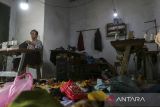 Pekerja menyelesaikan pembuatan pakaian di salah satu rumah produksi di sentra industri usaha konveksi Kelurahan Sukawana, Kota Serang, Banten, Sabtu (12/7/2025). Pemerintah mencatat realisasi penyaluran Kredit Usaha Rakyat (KUR) mencapai Rp131,84 triliun hingga semester I 2025 atau mencakup 45,86 persen dari target tahun ini yang sebesar Rp300 triliun, di mana 60 persen penyalurannya berhasil masuk ke sektor produksi yang menunjukkan KUR benar-benar mendorong produktivitas UMKM. ANTARA FOTO/Angga Budhiyanto/gp
