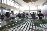 Calon pembeli berbincang saat memperhatikan maket Gallery Asthara Skyfront City dalam acara pemilihan unit di Marketing Gallery Asthara Skyfront City oleh konsumen, di Tangerang, Banten, Sabtu (12/7/2025).  Asthara Skyfront City merupakan perkotaan modern masa depan yang dibangun bersebelahan dengan Bandara Internasional Soekarno Hatta, dirancang sebagai ruang perkotaan mandiri, Kawasan ini mencakup kawasan hunian, pusat perbelanjaan dan bisnis terpadu, pada tahap pertama Cluster Allurea telah habis terjual dengan total nilai penjualan sekitar Rp.320 Milliar. ANTARA FOTO/Galih Pradipta