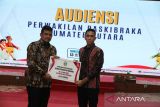 Gubernur Sumatera Utara Bobby Nasution (kiri) mengapresiasi berupa memberikan penghargaan kepada pelajar SMA Islam Plus Adzkia Medan Adinata Kurniawan Harahap (kanan) yang menjadi perwakilan Sumut paskibraka nasional 2025 di Rumah Dinas Gubernur Sumatera Utara, Medan (13/7/2025). Dalam  apresiasi tersebut, Bobby Nasution berpesan kepada Adinata Kurniawan untuk menjadi paskibraka yang menginspirasi masyarakat sekaligus bisa menjaga nama baik Sumut. ANTARA/Yudi Manar
