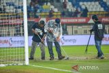 Petugas berusaha mengeluarkan air dari lapangan saat pertandingan Final Piala Presiden antara Oxford United melawan Port FC di Stadion Si Jalak Harupat, Kabupaten Bandung, Jawa Barat, Minggu (13/7/2025). Hujan deras yang mengguyur Stadion Si Jalak Harupat membuat lapangan tergenang dan pertandingan final diberhentikan untuk sementara. ANTARA FOTO/Raisan Al Farisi/agr
