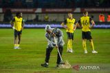 Petugas berusaha mengeluarkan air dari lapangan saat  pertandingan Final Piala Presiden antara Oxford United melawan Port FC di Stadion Si Jalak Harupat, Kabupaten Bandung, Jawa Barat, Minggu (13/7/2025). Hujan deras yang mengguyur Stadion Si Jalak Harupat membuat lapangan tergenang dan pertandingan final diberhentikan untuk sementara. ANTARA FOTO/Raisan Al Farisi/agr
