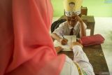 Guru memberikan pengajaran baca-tulis ke satu-satunya murid kelas 1 di SDN 1 Kendalrejo, Trenggalek, Jawa Timur, Senin (14/7/2025). Kendati hanya mendapatkan satu murid baru dalam penjaringan SPMB 2025, sekolah yang ada di pinggiran Kabupaten Trenggalek ini tetap memberikan pengajaran melalui program masa pengenalan lingkungan sekolah (MPLS) di hari pertama masuk sekolah. ANTARA Jatim/Destyan Sujarwoko/mas.