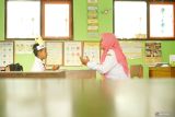 Guru memberikan pengajaran baca-tulis ke satu-satunya murid kelas 1 di SDN 1 Kendalrejo, Trenggalek, Jawa Timur, Senin (14/7/2025). Kendati hanya mendapatkan satu murid baru dalam penjaringan SPMB 2025, sekolah yang ada di pinggiran Kabupaten Trenggalek ini tetap memberikan pengajaran melalui program masa pengenalan lingkungan sekolah (MPLS) di hari pertama masuk sekolah. ANTARA Jatim/Destyan Sujarwoko/mas.