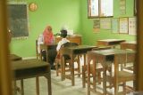 Guru memberikan pengajaran baca-tulis ke satu-satunya murid kelas 1 di SDN 1 Kendalrejo, Trenggalek, Jawa Timur, Senin (14/7/2025). Kendati hanya mendapatkan satu murid baru dalam penjaringan SPMB 2025, sekolah yang ada di pinggiran Kabupaten Trenggalek ini tetap memberikan pengajaran melalui program masa pengenalan lingkungan sekolah (MPLS) di hari pertama masuk sekolah. ANTARA Jatim/Destyan Sujarwoko/mas.