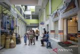 Warga berjalan di samping kios pedagang yang sudah mulai beroperasi di Pasar Anyar, Kota Tangerang, Banten, Senin (14/7/2025). Pemerintah Kota Tangerang membuka kembali Pasar Anyar setelah selesai direvitalisasi oleh Kementerian Pekerjaan Umum dengan kapasitas daya tampung 1.676 kios dan menjadi pasar pangan bersih, nyaman dan modern.  ANTARA FOTO/Putra M. Akbar/gp