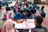 Siswa didampingi orang tua mengisi data untuk Sekolah Rakyat Bandung di Polteksos Bandung, Jawa Barat, Senin (14/7/2025). Sebanyak 52 siswa dan 48 siswi tingkat sekolah menengah atas mulai mengikuti masa pengenalan lingkungan sekolah dan asrama Sekolah Rakyat sebelum memulai kegiatan belajar mengajar yang dijadwalkan pekan depan. ANTARA FOTO/Novrian Arbi/agr