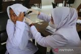 Petugas kesehatan memeriksa telinga seorang  siswi Sekolah Rakyat Menengah Atas saat pemeriksaan  kesehatan di gedung Renovasi Ali Hasjmy, desa Lam Ilie, kecamatan Indra Puri, kabupaten Aceh Besar, Aceh Senin (14/7/2025). Pemerintah secara serentak  melaunching Sekolah Rakyat di 63 titik dan sisanya sebanyak 37 titik dijadwalkan awal Agustus 2025.  ANTARA FOTO/Ampelsa