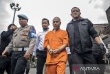 Polisi menggiring tersangka sebelum konferensi pers kasus tindak pidana pemalsuan uang rupiah di Polres Cimahi, Kota Cimahi, Jawa Barat, Senin (14/7/2025). Polres Cimahi mengungkap kasus tindak pidana pemalsuan mata uang rupiah atau uang kertas dengan mengamankan satu orang tersangka beserta barang bukti berupa satu buah printer, 268 lembar kertas roti, 2 buah cap gambar Bank Indonesia, 10 kaleng cat semprot, 150 lembar uang palsu siap potong, 77 lembar uang palsu pecahan Rp100 ribu dan 184 lembar uang palsu pecahan Rp50 ribu. ANTARA FOTO/Abdan Syakura/agr
