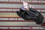 Tangan Kapolres Cimahi AKBP Niko Narullah Adi Putra memeriksa keaslian uang rupiah saat konferensi pers kasus tindak pidana pemalsuan uang rupiah di Polres Cimahi, Kota Cimahi, Jawa Barat, Senin (14/7/2025). Polres Cimahi mengungkap kasus tindak pidana pemalsuan mata uang rupiah atau uang kertas dengan mengamankan satu orang tersangka beserta barang bukti berupa satu buah printer, 268 lembar kertas roti, 2 buah cap gambar Bank Indonesia, 10 kaleng cat semprot, 150 lembar uang palsu siap potong, 77 lembar uang palsu pecahan Rp100 ribu dan 184 lembar uang palsu pecahan Rp50 ribu. ANTARA FOTO/Abdan Syakura/agr
