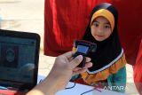 Seorang anak menjalani perekaman data untuk pembuatan Kartu Identitas Anak (KIA) melalui layanan jemput bola Disdukcapil Kota Pontianak di area Car Free Day (CFD) Pontianak, Kalimantan Barat, Minggu (13/7/2025). Dinas Kependudukan dan Pencatatan Sipil (Disdukcapil) Kota Pontianak membuka layanan perekaman Kartu Identitas Anak (KIA) di area CFD untuk mempermudah masyarakat mengurus dokumen kependudukan. ANTARA FOTO/Jessica Wuysang