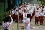 Sejumlah siswa sekolah dasar mengikuti upacara bendera pada hari pertama masuk sekolah di Madrasah Ibtidaiyah Negeri (MIN) 1 Pontianak, Kalimantan Barat, Senin (14/7/2025). Setelah libur sekolah, siswa-siswi mulai mengikuti pelajaran tahun ajaran baru 2025/2026 yang ditandai dengan dimulainya kembali aktivitas belajar mengajar di sekolah. ANTARA FOTO/Jessica Wuysang