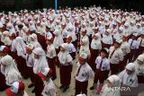 Sejumlah siswa sekolah dasar mengikuti upacara bendera pada hari pertama masuk sekolah di Madrasah Ibtidaiyah Negeri (MIN) 1 Pontianak, Kalimantan Barat, Senin (14/7/2025). Setelah libur sekolah, siswa-siswi mulai mengikuti pelajaran tahun ajaran baru 2025/2026 yang ditandai dengan dimulainya kembali aktivitas belajar mengajar di sekolah. ANTARA FOTO/Jessica Wuysang