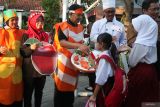 Sejumlah guru menyambut kedatangan pelajar di SD Negeri Kaliasin I, Surabaya, Jawa Timur, Senin (14/7/2025). Hari pertama masuk sekolah di sekolah itu sejumlah tenaga pendidik dan pelajar mengenakan kostum bertema Isi Piringku yang menggambarkan berbagai makanan, minuman serta bahan pangan lain sebagai upaya untuk mengenalkan kepada pelajar terutama murid baru tentang bahan pangan yang sehat bergizi. ANTARA Jatim/Didik Suhartono/mas.