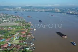 Foto udara sejumlah kapal tongkang pengangkut batu bara melintas di Sungai Mahakam, Samarinda, Kalimantan Timur, Minggu (13/7/2025). Menurut data dari Kementerian Energi dan Sumber Daya Mineral (ESDM) pada 2025, produksi batu bara Indonesia ditargetkan menjadi 739.674 juta ton, untuk realisasi hingga Mei sudah 357,6 juta ton dengan nilai sampai Mei mencapai 12.350 miliar dolar AS. Antara Kaltim/M Risyal Hidayat/nz 