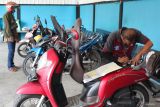 Petugas memeriksa nomor rangka sepeda motor milik warga di Samsat Surabaya Utara, Surabaya, Jawa Timur, Senin (14/7/2025). Pemprov Jawa Timur membuat kebijakan pembebasan pajak daerah bagi masyarakat Jawa Timur pemilik kendaraan bermotor roda dua dan roda tiga yang masuk dalam data Penyasaran Percepatan Penghapusan Kemiskinan Ekstrem (P3KE), beberapa di antaranya bebas sanksi administrasi keterlambatan Pajak Kendaraan Bermotor (PKB) dan Bea Balik Nama Kendaraan Bermotor (BBNKB), bebas PKB progresif serta bebas denda dan pokok tunggakan PKB tahun 2024 dan tahun sebelumnya, yang berlangsung sampai 31 Agustus 2025. Antara Jatim/Didik Suhartono/um