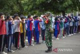Anggota Babinsa Koramil 1602 Sindang Indramayu memberikan pelatihan baris-berbaris kepada pelajar pada  Masa Pengenalan Lingkungan Sekolah (MPLS) di SMA Negeri 1 Sindang, Indramayu, Jawa Barat, Selasa (15/7/2025). Pemerintah Provinsi Jawa Barat melibatkan unsur TNI dan Polri dalam pelaksanaan Masa Pengenalan Lingkungan Sekolah (MPLS) tahun ajaran 2025/2026 untuk meningkatkan kedisiplinan dan pencegahan perilaku menyimpang dengan pembekalan materi tentang ketertiban berlalu lintas, baris berbaris dan materi wawasan kebangsaan bagi siswa. ANTARA FOTO/Dedhez Anggara/agr