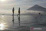 Pengunjung berenang di kolam renang air hangat alami saat menikmati sunrise Gunung Cikuray di Agrowisata Tepas Papandayan, Desa Karamatwangi, Kecamatan Cisurupan, Kabupaten Garut, Jawa Barat, Rabu (16/7/2025). Agrowisata Tepas Papandayan yang dibangun pada tahun 2019 oleh Pemerintah Desa dan dikelola Badan Usaha Milik Desa (BUMDes) Keramat Jaya itu mampu menghasilkan Pendapatan Asli Desa (PAD) sebesar Rp100 juta-Rp150 juta per tahun. ANTARA FOTO/Adeng Bustomi/agr