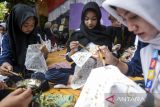 Siswa belajar mencanting batik saat Festival Batik Tangerang di Desa Kemuning, Kabupaten Tangerang, Banten, Rabu (16/7/2025). Festival yang berlangsung selama tiga hari tersebut menampilkan kegiatan berupa belajar membuat batik, lomba menggambar motif batik serta pameran seni kriya sebagai upaya mengenalkan dan melestarikan batik sebagai warisan budaya Indonesia. ANTARA FOTO/Putra M. Akbar/gp