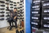 Pelaku UMKM menjual sepatu melalui siaran langsung di salah satu lokapasar di rumah produksi sepatu Lalaki Footwear, Cibaduyut, Bandung, Jawa Barat, Selasa (15/7/2025). Menteri Keuangan Sri Mulyani Indrawati resmi mengeluarkan aturan pemungutan pajak e-commerce kepada seller atau penjual daring di lokapasar dengan ketentuan penjual yang memiliki omzet di atas Rp500 juta per tahun akan dikenakan pajak penghasilan (PPh) Pasal 22 sebesar 0,5 persen dari omzet bruto yang diterima dalam setahun, sedangkan bagi yang memiliki omzet setara atau di bawah Rp500 juta per tahun tidak dipungut PPh dan nantinya pemungutan pajak itu akan dilakukan oleh lokapasar yang termasuk dalam Penyelenggara Perdagangan Melalui Sistem Elektronik (PMSE) yang telah ditunjuk oleh Kementerian Keuangan. ANTARA FOTO/Abdan Syakura/agr