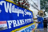 Maskot tim Persib Bandung menempelkan huruf di karangan bunga yang berisikan pesan selamat datang bagi pemain Persib Bandung yang baru di Jalan Asia Afrika, Bandung, Jawa Barat, Rabu (16/7/2025). Manajemen Tim Persib Bandung mengumumkan pemain asing baru ke-9 yaitu Frans Putros asal Irak melalui media karangan bunga di Jalan Asia Afrika setelah sebelumnya menggunakan media videotron, radio, koran, dan kartu pos. ANTARA FOTO/Raisan Al Farisi/agr