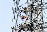 Pekerja memasang kawat penghantar pada menara Saluran Udara Tegangan Ekstra Tinggi (SUTET) di Waru, Sidoarjo, Jawa Timur, Rabu (16/7/2025). Pemerintah melalui Kementerian Energi dan Sumber Daya Mineral (ESDM) memutuskan tarif tenaga listrik PT PLN (Persero) Triwulan III atau periode Juli-September Tahun 2025 untuk 13 golongan pelanggan nonsubsidi tidak mengalami perubahan atau tetap untuk meningkatkan daya beli masyarakat dan daya saing industri. Antara Jatim/Umarul Faruq
