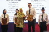 Gubernur Jawa Timur Khofifah Indar Parawansa (tengah) menyerahkan Surat Keputusan (SK) kepada salah satu perwakilan CPNS saat acara penyerahan SK dan pembekalan CPNS serta Pegawai Pemerintah dengan Perjanjian Kerja (PPPK) di Graha Unesa, Surabaya, Jawa Timur, Rabu (16/7/2025). Dalam kegiatan tersebut Gubernur Khofifah menyerahkan sebanyak 4.172 SK pengangkatan sebagai ASN yang terdiri dari 2.015 PPPK dan 2.157 CPNS serta memberikan pembekalan untuk penguatan kapasitas dan kualitas SDM ASN. ANTARA Jatim/Moch Asim.